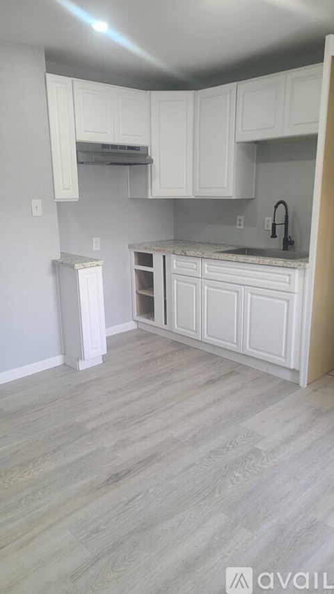 A kitchen with white cabinets and a marble countertop.