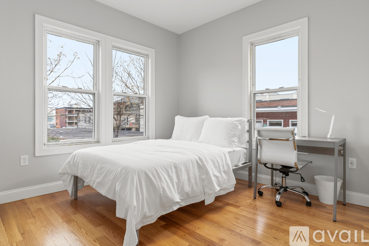 A bedroom with a bed, desk, and chair.