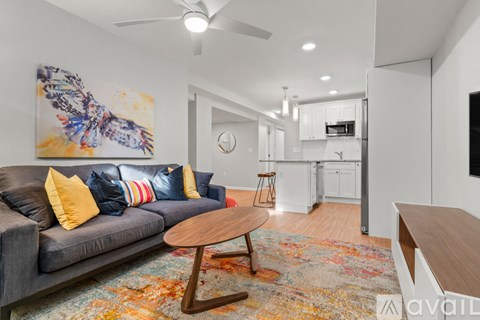 A living room with a grey couch and a wooden coffee table.