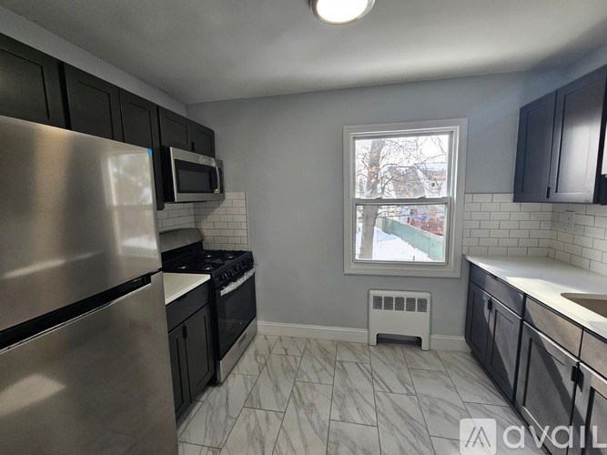 A kitchen with a stainless steel refrigerator, microwave, and oven.