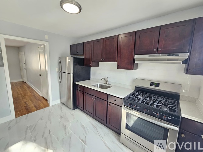 A kitchen with dark brown cabinets and a stainless steel refrigerator.