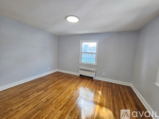 A room with wooden flooring and a window.