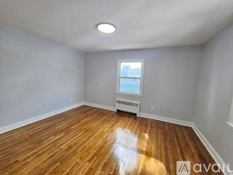 A room with wooden flooring and a window.
