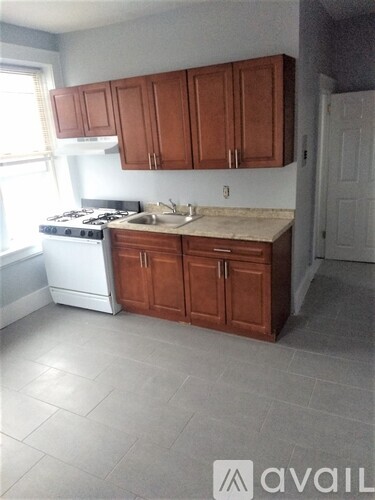 A kitchen with brown cabinets and a white stove.