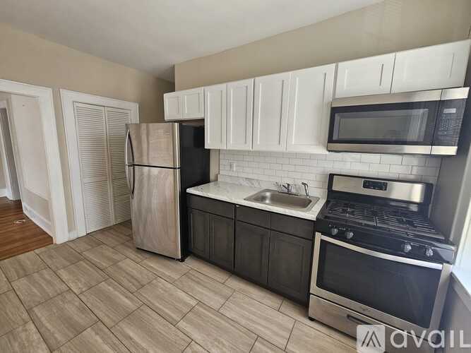 A kitchen with a refrigerator, oven, microwave, and sink.