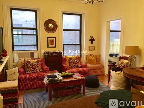 A living room with a red couch and a wooden coffee table.