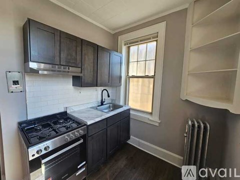 A kitchen with a stove top oven and a window.