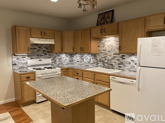 A kitchen with wooden cabinets and a granite countertop.
