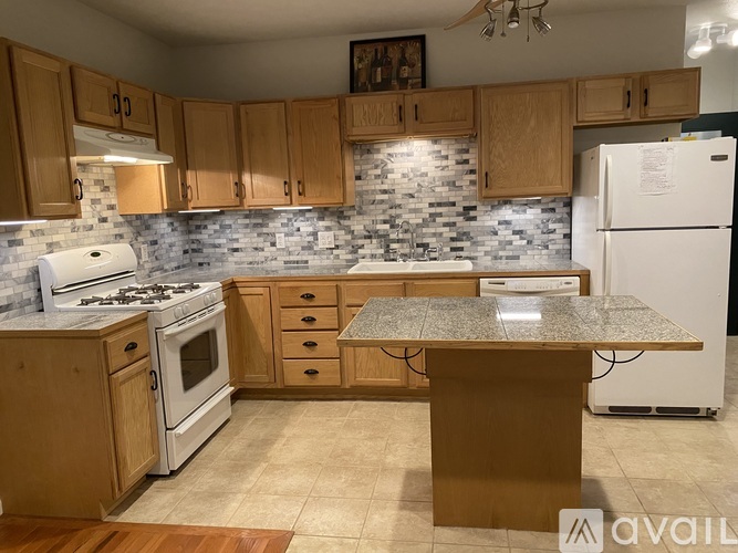 A kitchen with wooden cabinets and a granite countertop.