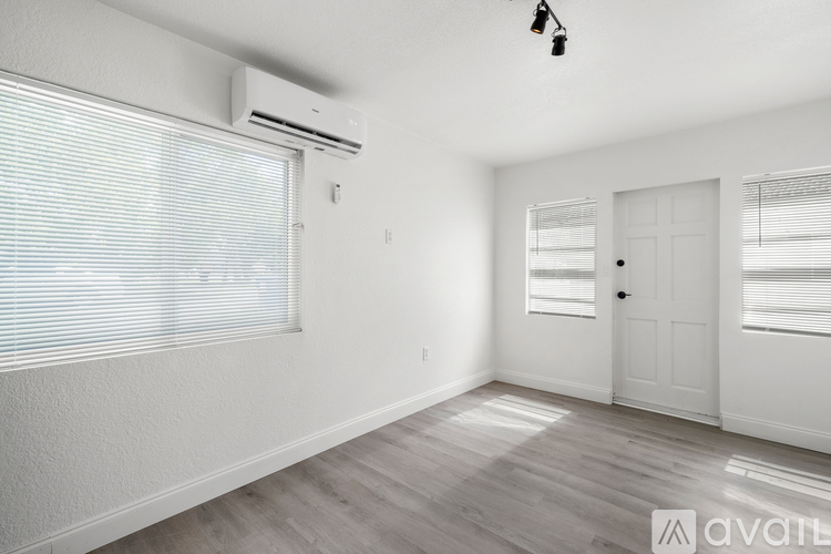 A room with a white door, window with blinds, and a ceiling fan.
