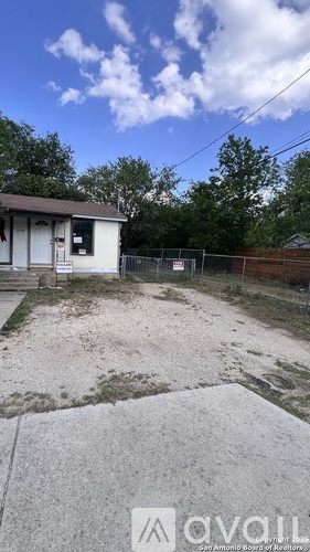 A small house with a fence and a sign that says "available" in front of it.