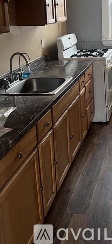 A kitchen with wooden cabinets and a white stove.