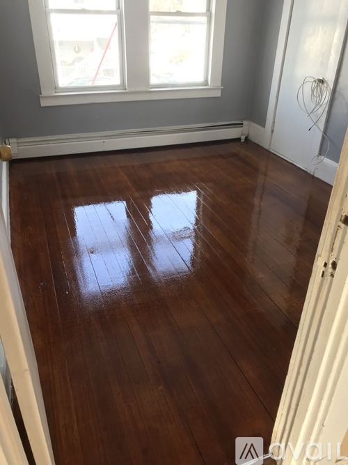 A room with a wooden floor and a window.