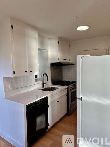 A kitchen with white cabinets and a black oven.