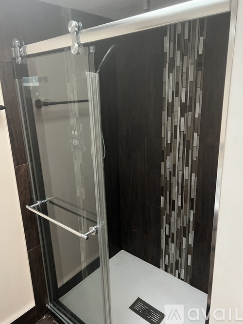 A glass shower stall with a white door and a glass door.