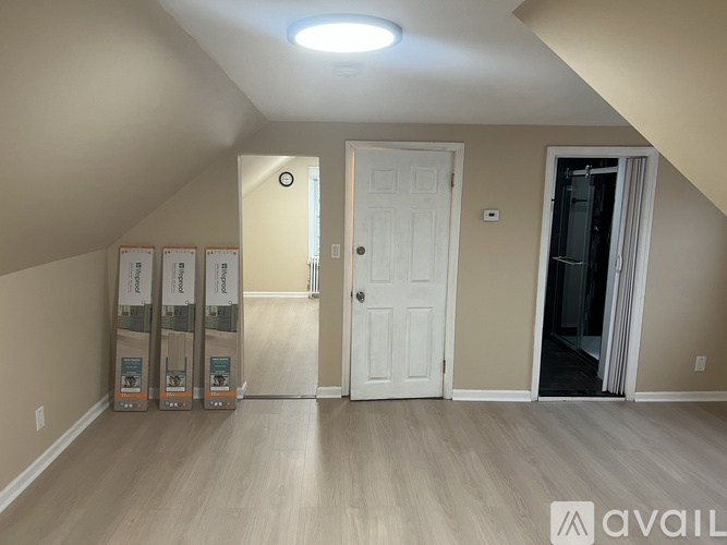 A room with a white door and a light on the ceiling.