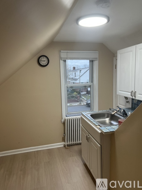 A kitchen with a window and a clock on the wall.