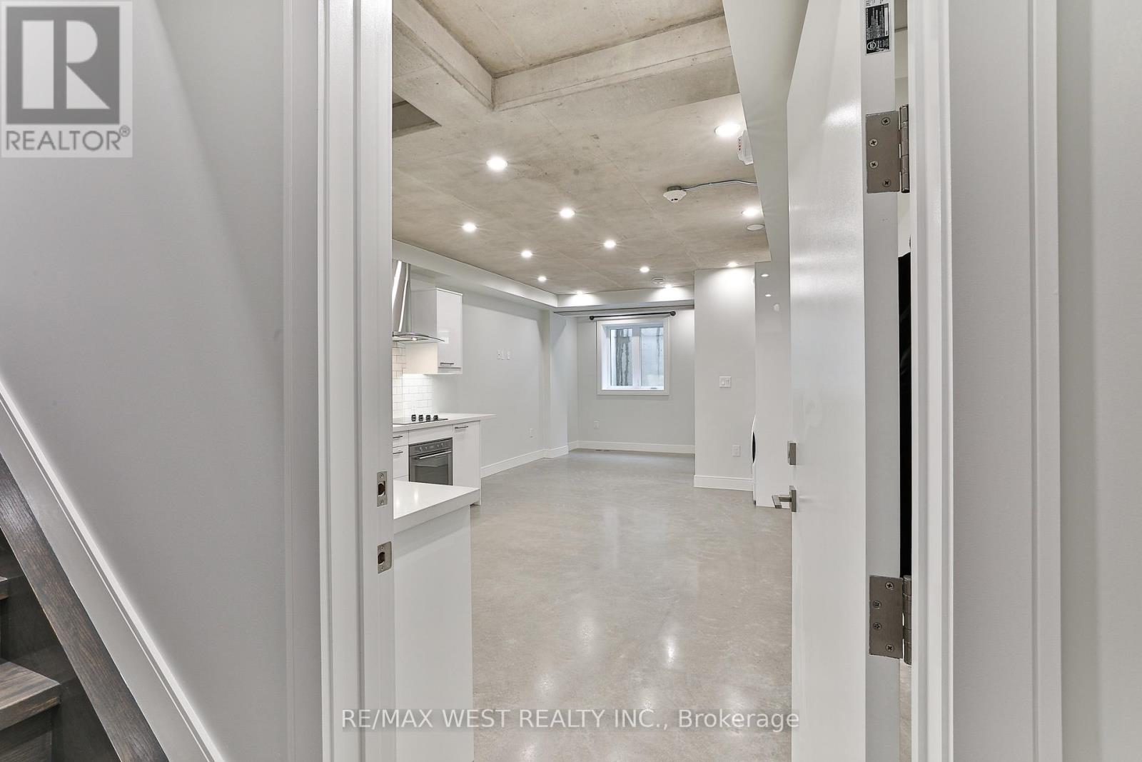 A spacious, well-lit room with a staircase on the left side.