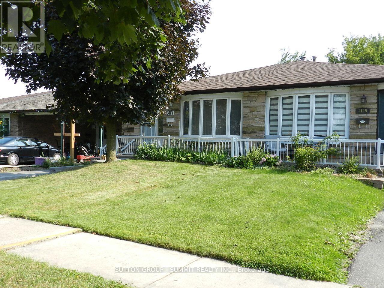 A house with a white fence and a green lawn.