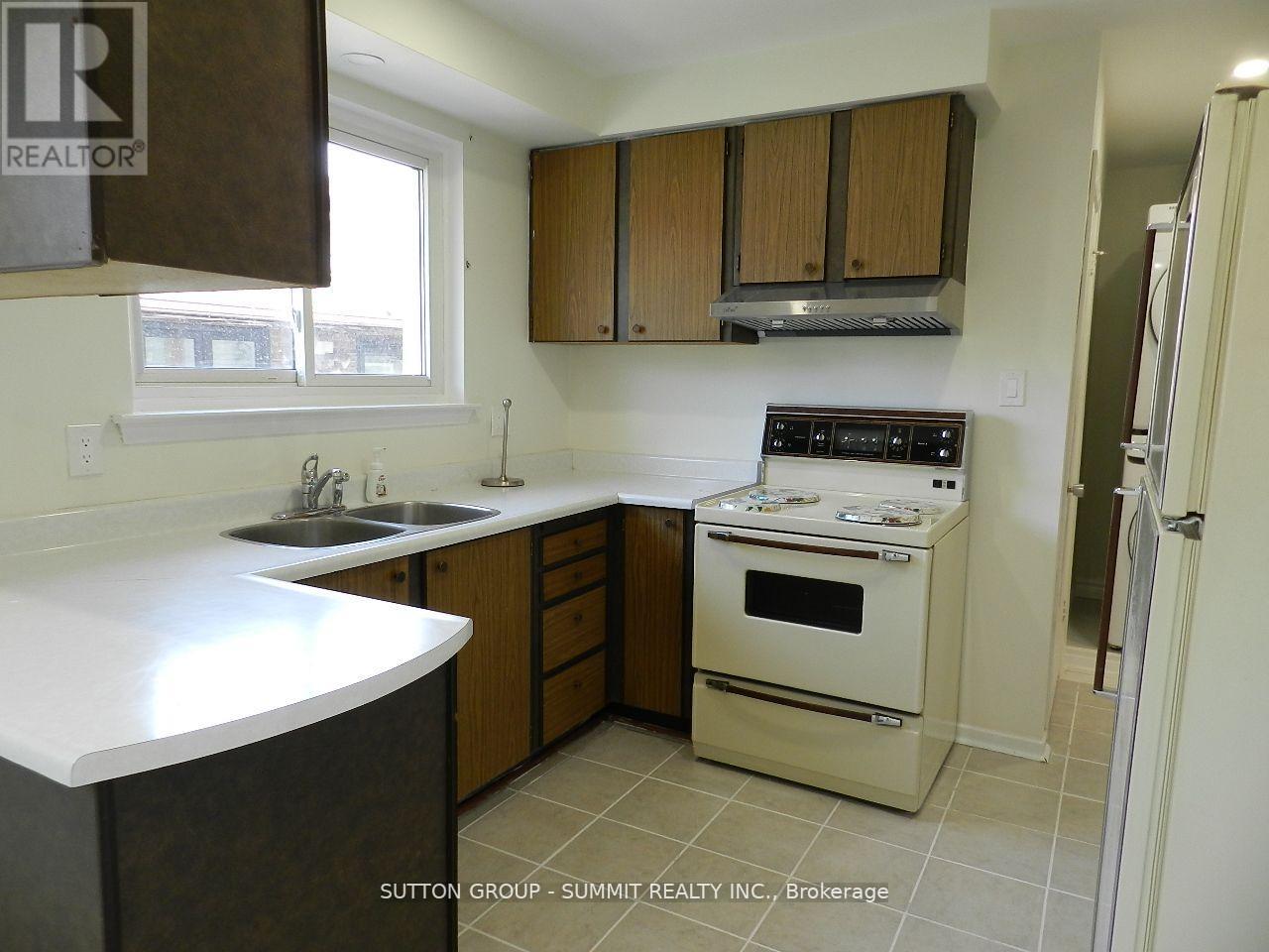 A kitchen with a stove top oven and a sink.