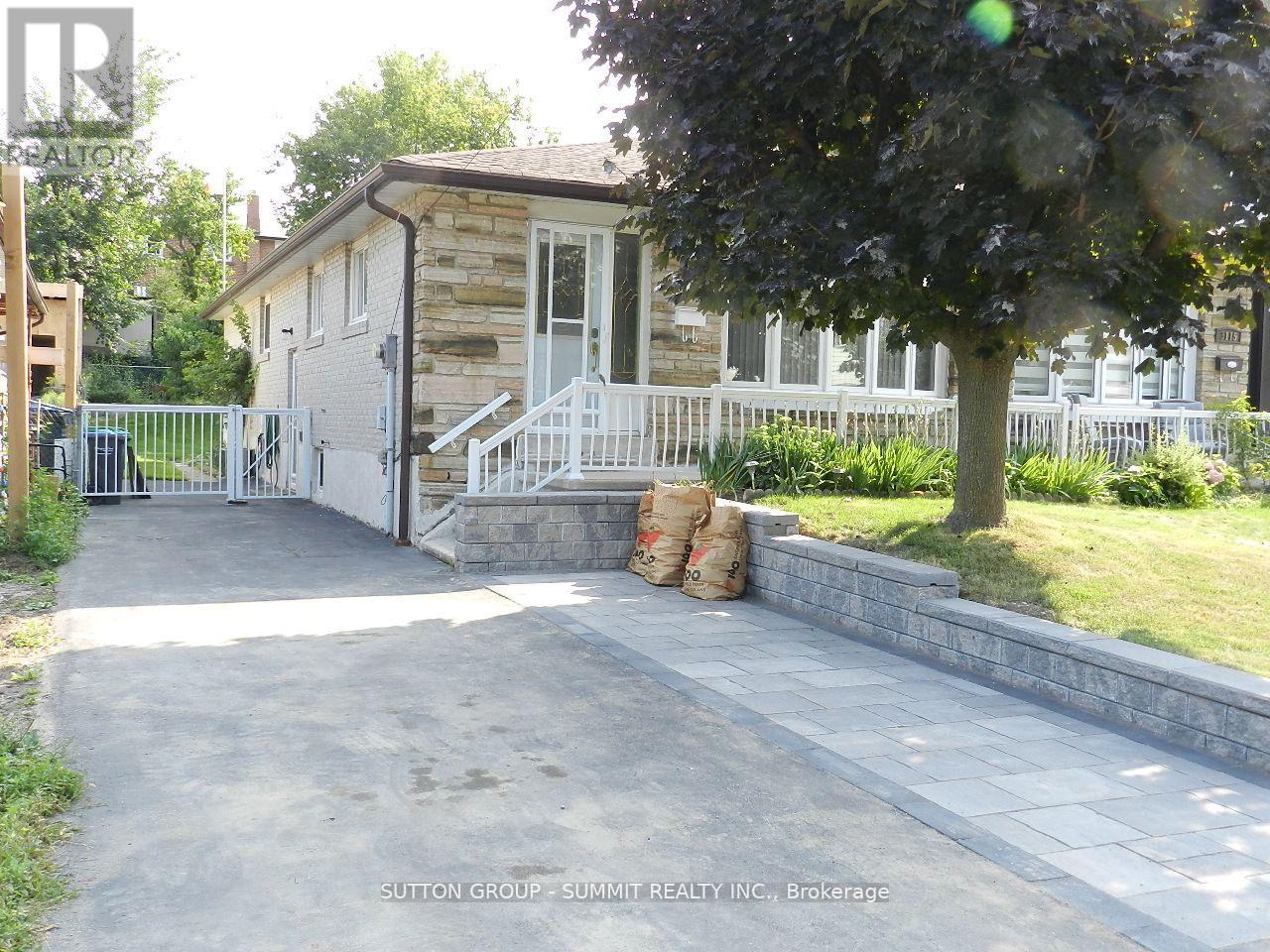 A house with a white fence and a tree in front of it.