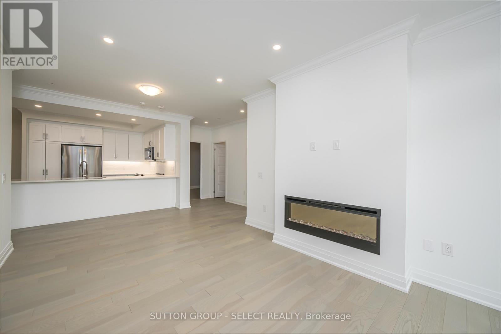 A spacious room with a fireplace and a bar area in the background.