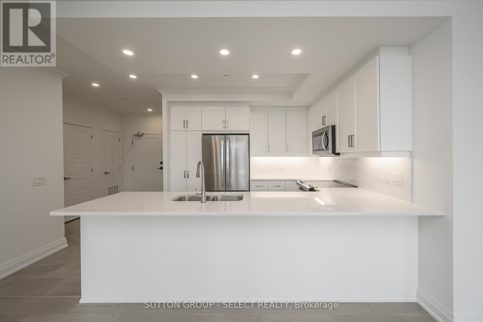 A modern kitchen with white cabinets and a central island.