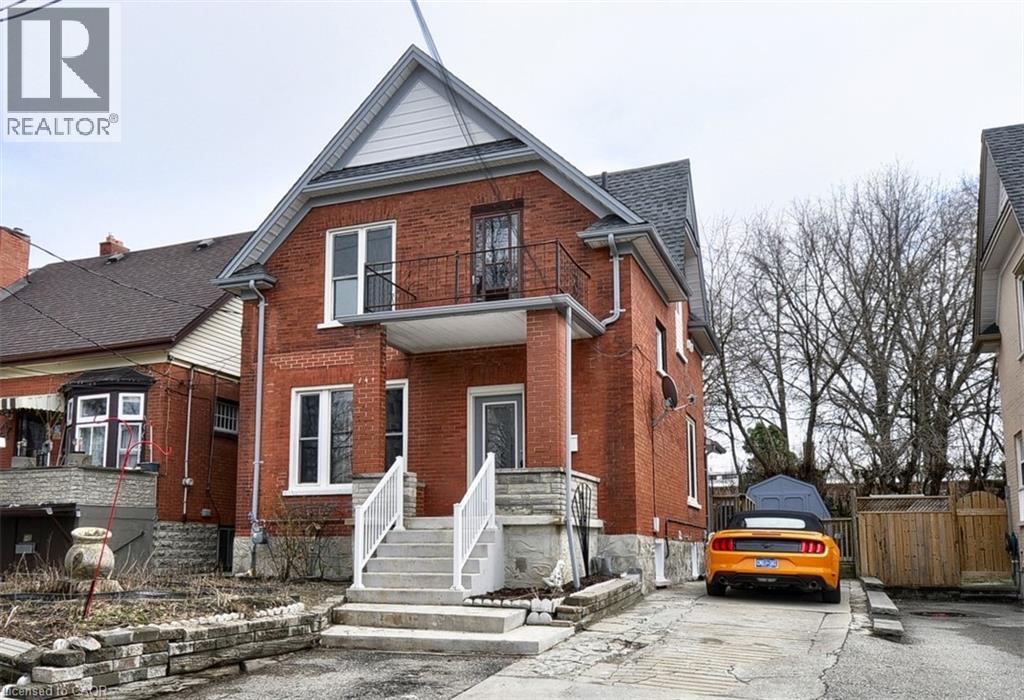 A red brick house with a car parked in front.