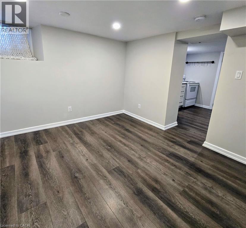 A room with wood flooring and a doorway leading to another room.