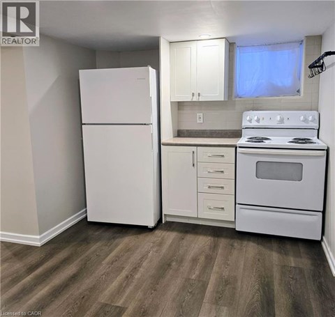 A white refrigerator and stove in a kitchen with wood flooring.