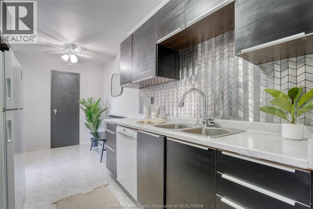 A kitchen with a sink and a refrigerator.