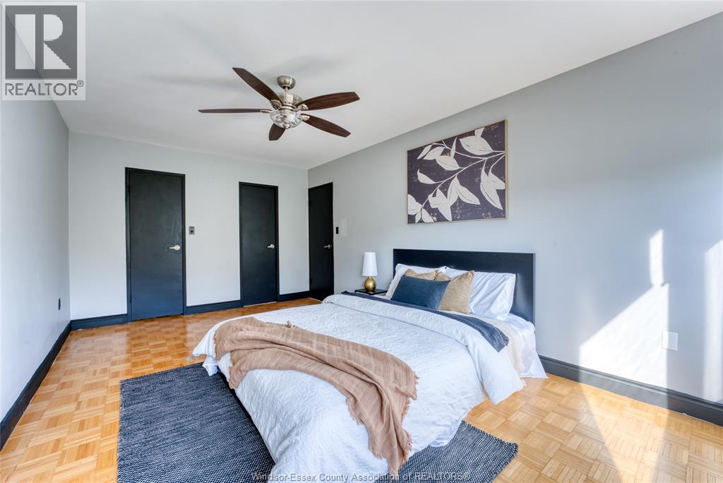 A bedroom with a large bed and a ceiling fan.