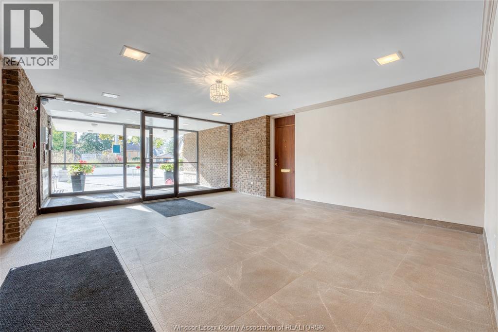 A spacious room with a brick wall and a large window.
