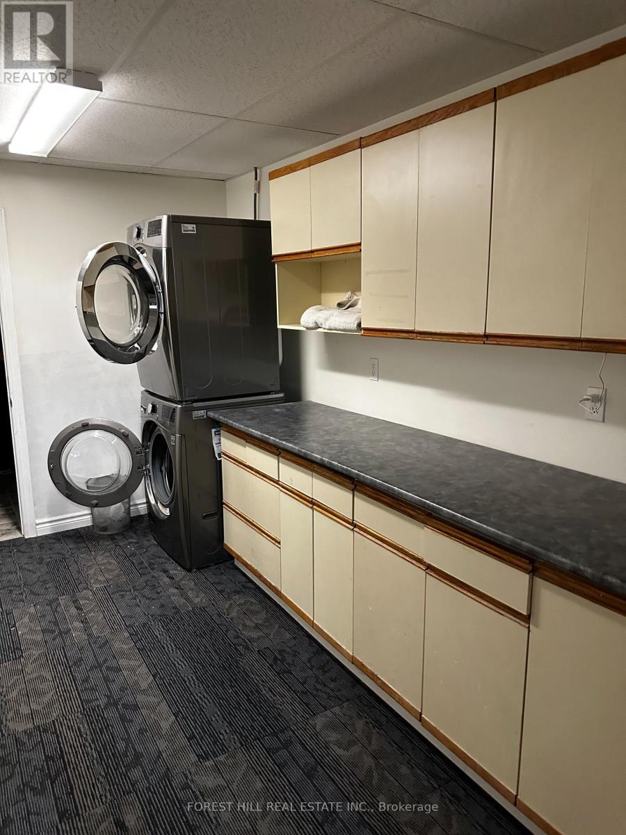 A black fridge and washing machine in a kitchen.