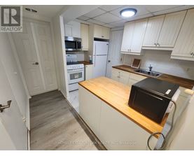 A kitchen with a microwave, oven, and refrigerator.