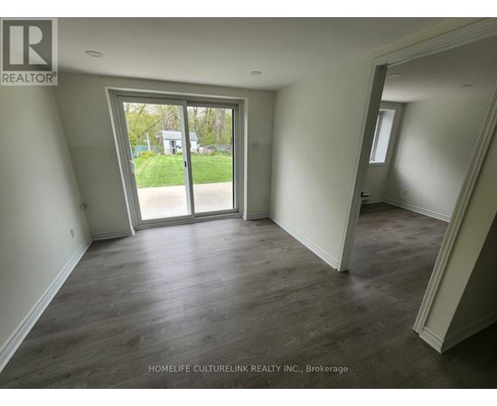 A room with a sliding glass door leading to a backyard.