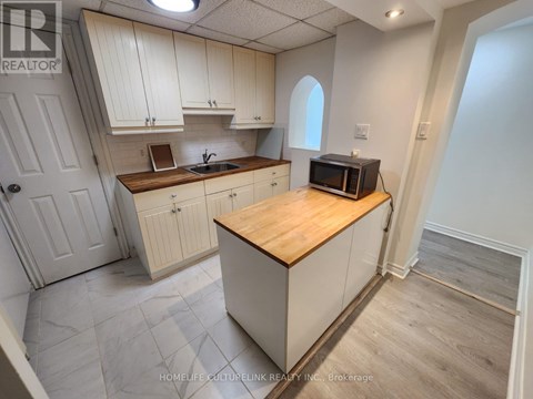 A kitchen with white cabinets and a wooden island.