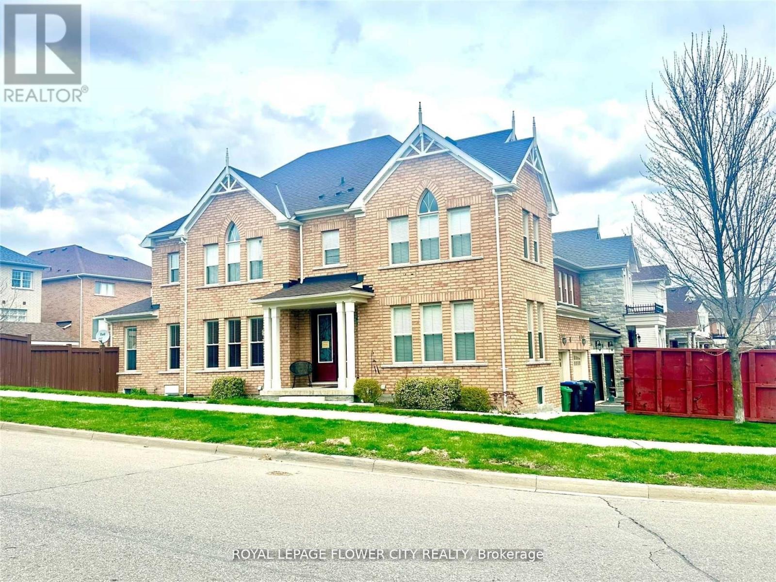 A brick house with a red door and a sign that says "Royal LePage Flower City Realty, Brokerage.".