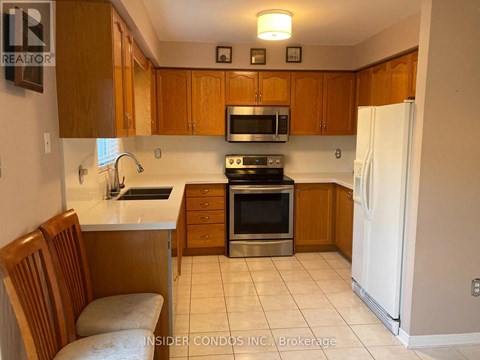 A kitchen with wooden cabinets and a white refrigerator.