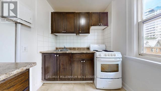 A kitchen with a white stove and wooden cabinets.