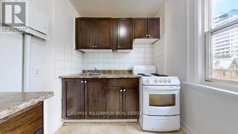 A kitchen with a white stove and wooden cabinets.