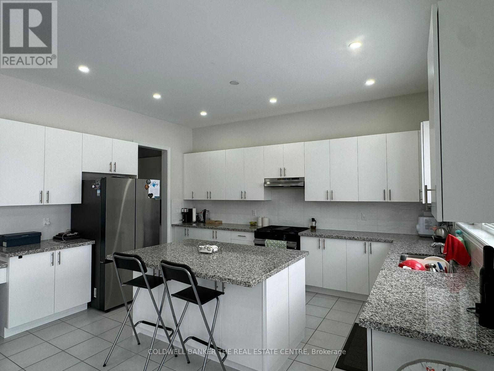 A kitchen with granite countertops and white cabinets.
