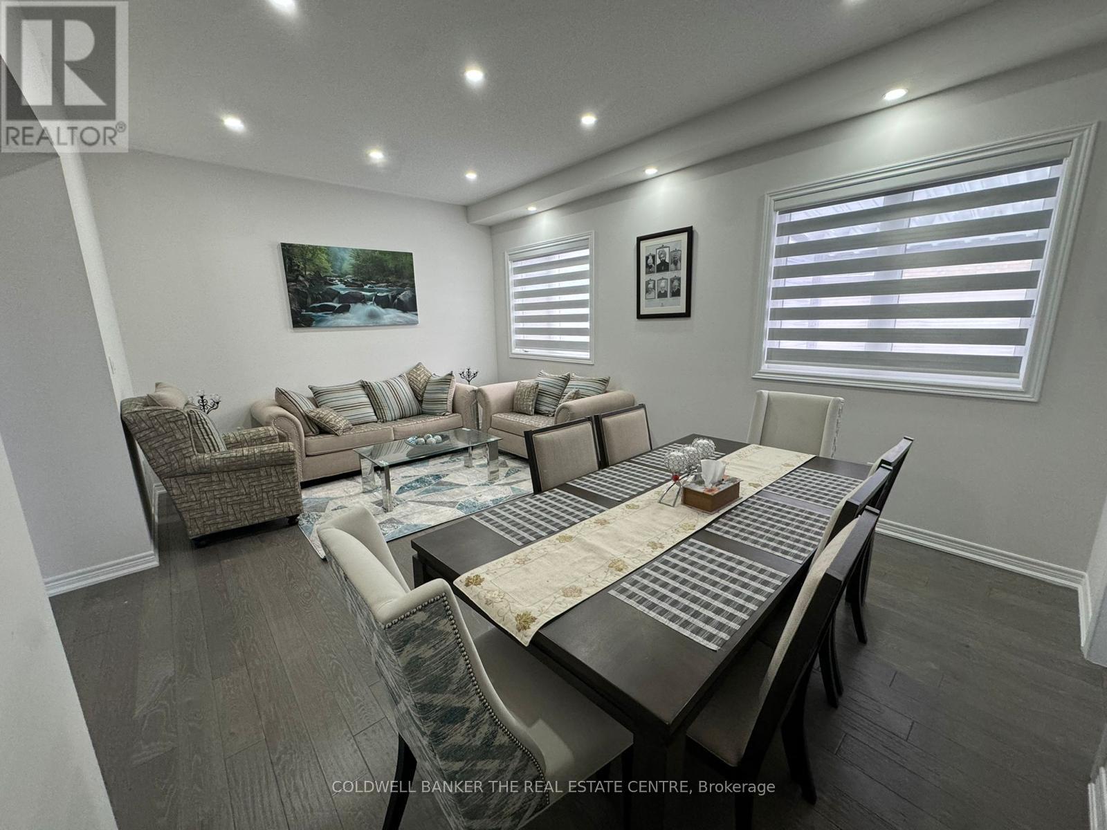A well-lit, spacious living room with a dining table and chairs.