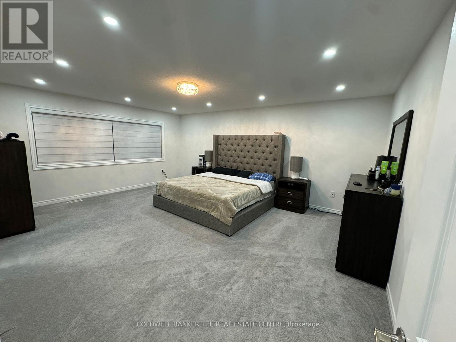 A bedroom with a bed, nightstand, and a dresser.