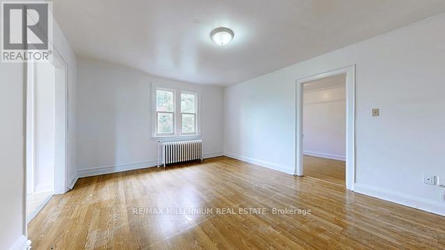 A spacious room with wooden floors and white walls.