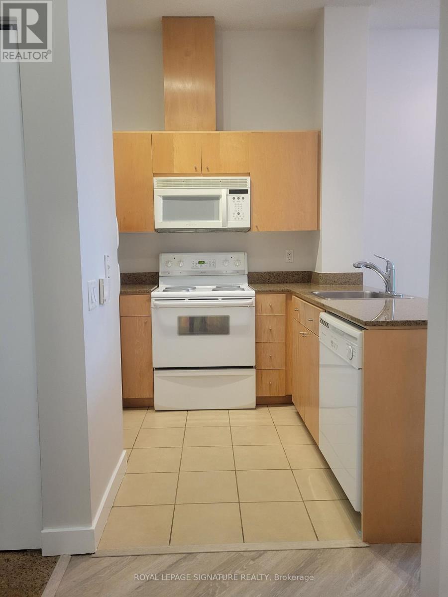 A kitchen with white appliances and wooden cabinets.