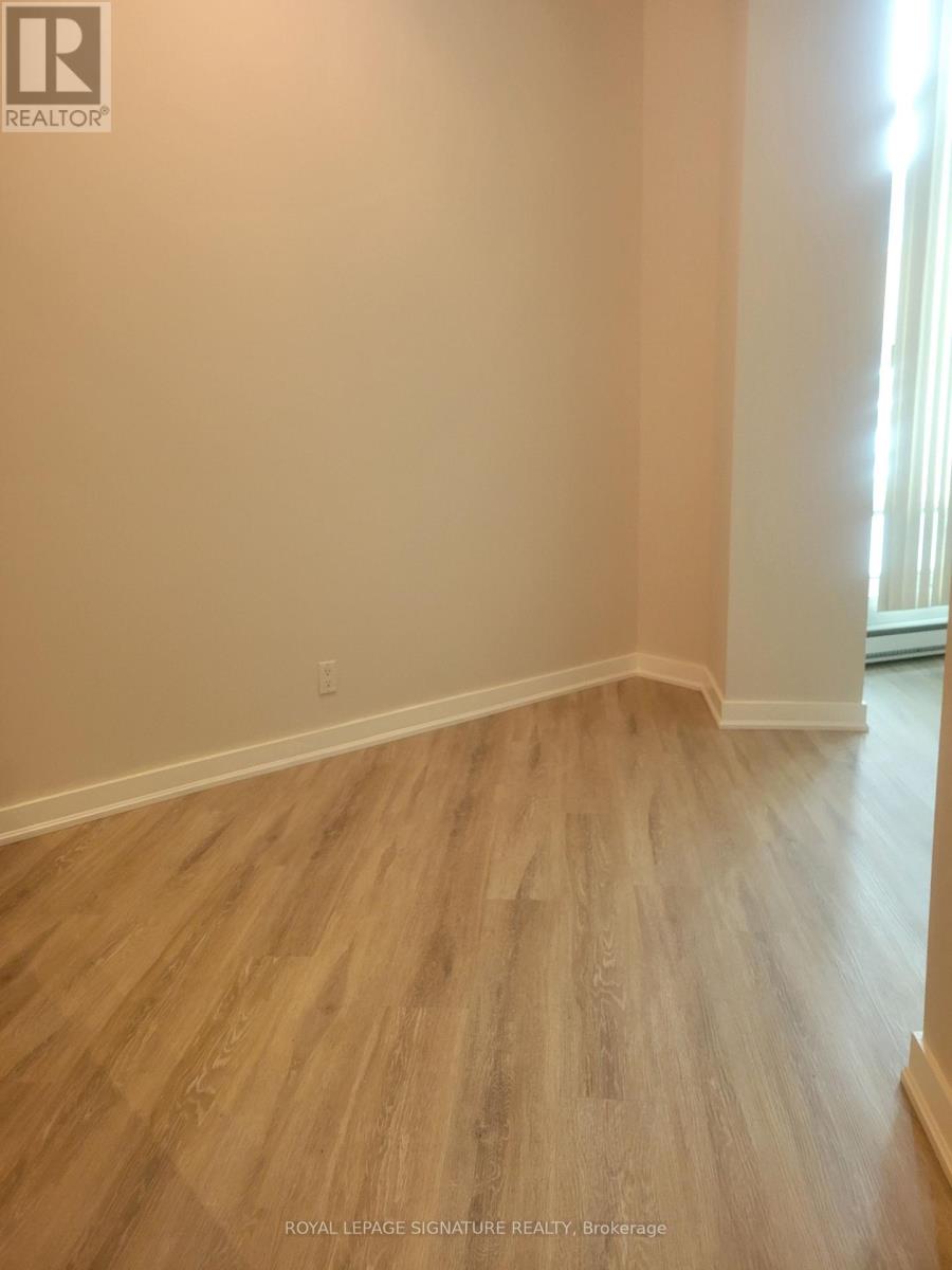 A room with wooden flooring and white walls.