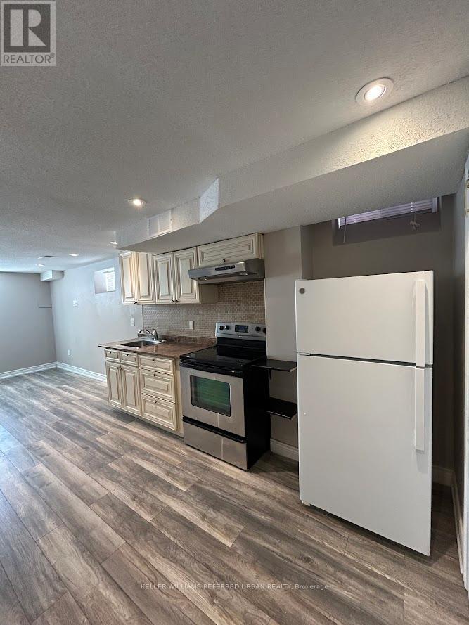 A kitchen with a white refrigerator and wooden floors.