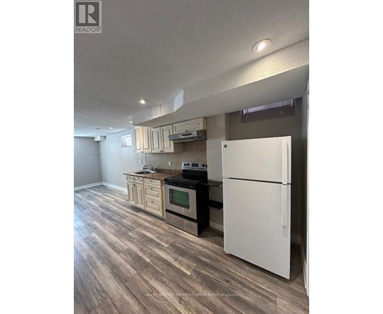 A kitchen with a white refrigerator and wooden floors.