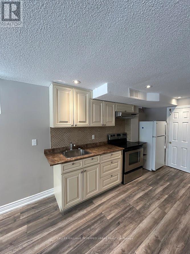 A kitchen with wooden floors and cabinets.